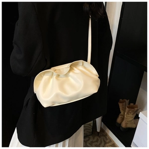 Détail du sac nuage plissé blanc cassé avec fine bandoulière porté par un mannequin