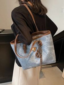 Sac cabas vintage gris avec anses en cuir marron et accessoire de charme biscuit