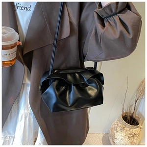 Détail du sac nuage noir plissé avec bords volantés élégants et fine bandoulière réglable