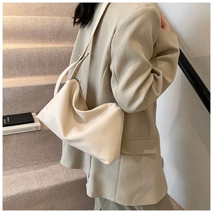 Sac hobo chic en cuir crème porté avec un blazer oversize pour un look de bureau élégant