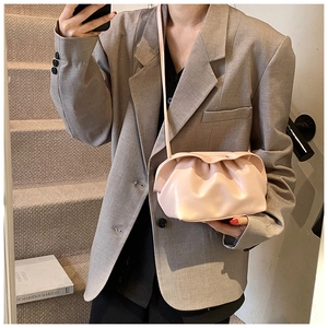 Détail du sac nuage plissé rose clair avec fine bandoulière porté par un mannequin