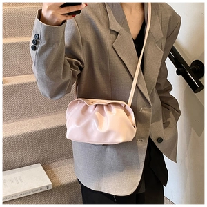 Détail du sac nuage plissé rose en cuir mat avec une fine bandoulière élégante