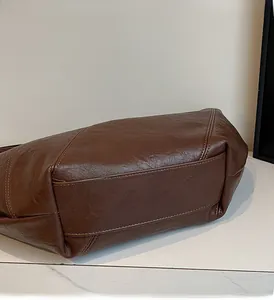 Detailed close-up showing precise stitching and premium dark brown leather texture