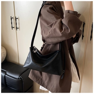 Détail d'un cabas vintage en cuir noir avec un tirette de zip en forme de main argentée
