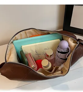 Detail showing high-capacity brown crossbody bag with tablet and daily essentials