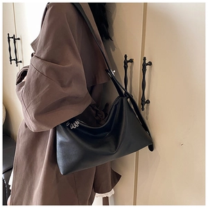 Détails du sac hobo noir minimaliste montrant la boucle argentée et la texture mate chic