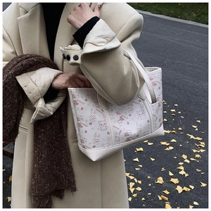Detail der weißen Tragetasche mit süßen Katzen-Prints und stabilen Griffen im Herbst-Look