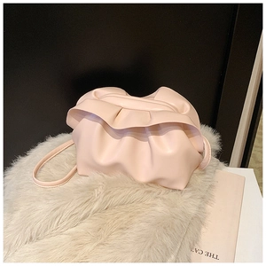 Vue détaillée du sac nuage froncé rose clair sur un fond texturé en peluche beige