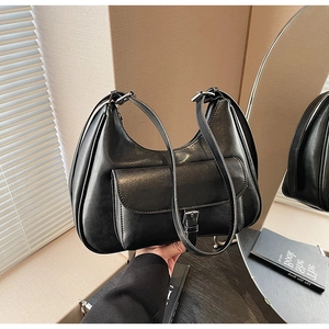 Detail shot of black faux leather hobo bag with front buckle pocket and zipper closure