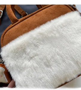 Detail of brown faux suede and white plush faux fur stitching on the casual shoulder bag