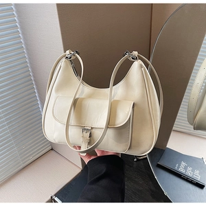 Close-up of off-white faux leather underarm bag with silver buckle and front pocket