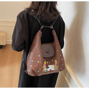Detail shot of a brown tote bag featuring colorful polka dots and cute dog embroidery