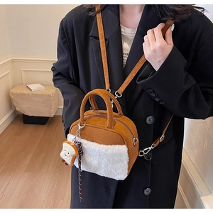 Detail of small brown suede handbag with white faux fur panel and cute toast plush charm
