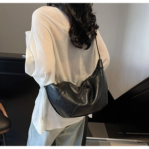 Foto lifestyle di una grande borsa hobo in pelle oleata nera con pieghe naturali