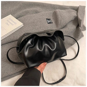 Détail d'un sac nuage plissé noir en similicuir brillant avec fine bandoulière