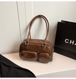 Dettaglio della borsa a spalla in pelle verniciata marrone scuro con tasche con zip frontali