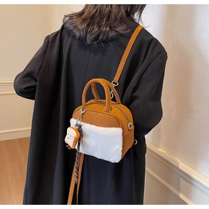 Detail of trendy crossbody bag with faux suede and white fluffy fur on model