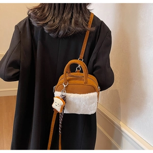 Rear view of a model wearing a mini crossbody bag with white fur trim and toast charm