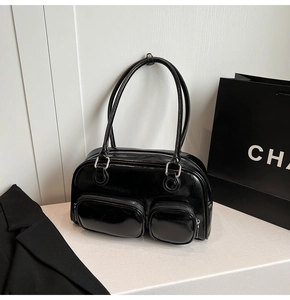 Dettaglio borsa bowling nera lucida con tasche con cerniera argento e manici superiori