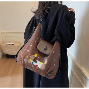 Close-up of brown crossbody bag with colorful dots and a cute cartoon puppy patch