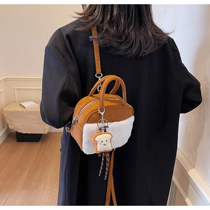 Detail of brown suede tote with white faux fur and cute toast plush toy charm attached