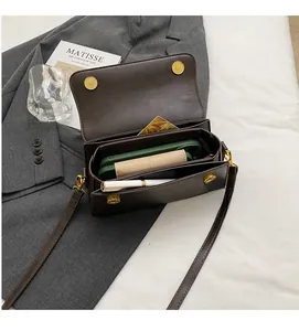 Detail showing the dual-compartment interior space of this brown leather crossbody bag