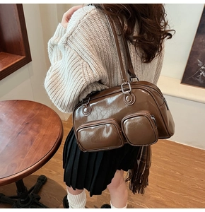 Dettaglio borsa a spalla vintage marrone lucido con due tasche frontali a zip