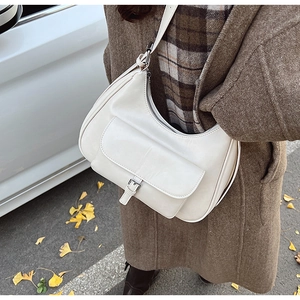 Detailed macro view of the cream leather texture and silver buckle on the hobo bag