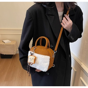 Detail of cute toast charm and plush faux fur trim on a brown mini crossbody bag