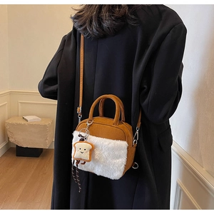 Detail of faux fur crossbody bag with cute smiling toast charm and plush texture