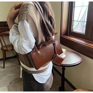 Detail of vintage brown leather shoulder bag with matching square coin purse charm