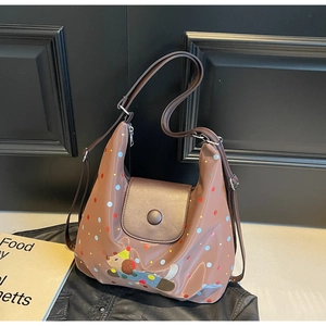 Brown polka dot tote bag with cartoon dog patch and shiny finish on a black background