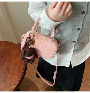 Pink suede crossbody bag with embossed lettering and cute brown teddy bear keychain charm