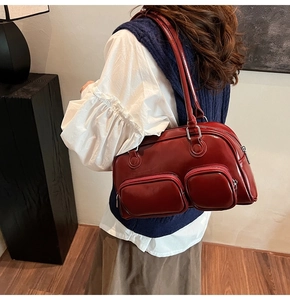 Vista dettagliata della borsa bowling retrò rosso scuro con tasche quadrate e finitura lucida