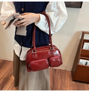 Dettaglio macro della borsa bowling in pelle PU rosso scuro lucido con tasche frontali