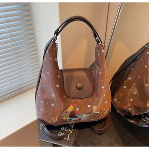 Detail of a brown PU leather shoulder bag with colorful polka dots and puppy embroidery