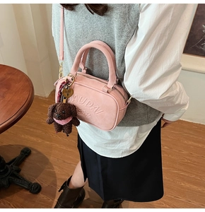Pink boston bag with suede texture, teddy charm, and heart padlock detail