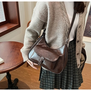 Detail view of a vintage brown leather Hobo underarm bag with a front buckle pocket