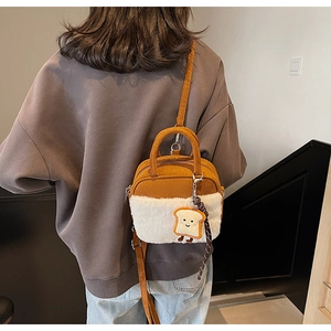 Detail view of mini plush crossbody bag with cartoon toast charm on a model