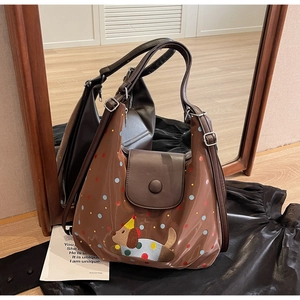 Close-up of brown glossy tote bag featuring colorful polka dots and cute dog embroidery