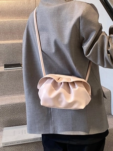 Sac à bandoulière rose plissé style nuage porté avec un blazer gris élégant