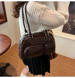 Dettaglio borsa bowling vintage marrone scuro con finitura lucida e doppie tasche frontali