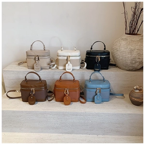 Multiple colors of minimalist bucket handbags arranged on stone steps in a stylish row