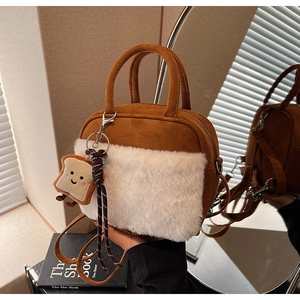 Detail of caramel suede bag with white faux fur and a cute toast-shaped plush charm