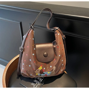 Detailed view of dark brown crossbody bag featuring colorful polka dots and a cute dog embroidery