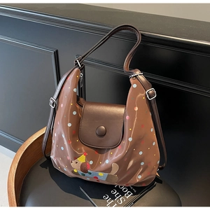 Detailed close-up of brown tote bag with colorful dots and cartoon dog embroidery