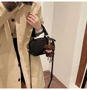 Chic black nylon Boston bag with LAUDAY embossing and cute puppy charm on a model