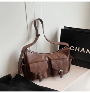 Detail view of brown vintage textured shoulder bag with double front flap pockets