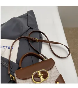 Close-up of brown and cream patchwork handbag with golden oval clasp and woven texture