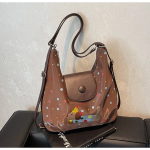 Close-up of brown crossbody bag with colorful dots and a cute puppy embroidery detail